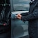 A private driver opening the door of a luxury mini bus